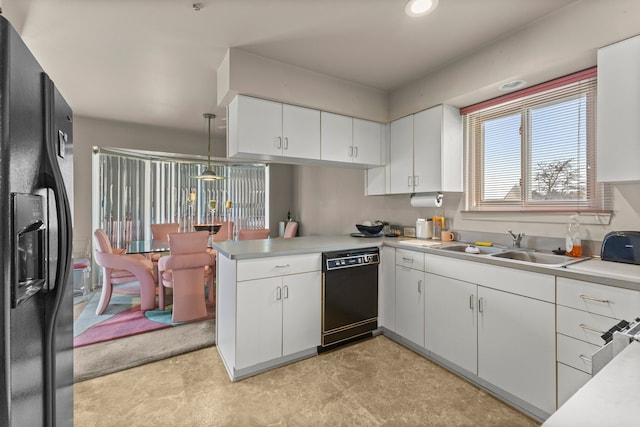 kitchen featuring sink, decorative light fixtures, black appliances, kitchen peninsula, and white cabinets