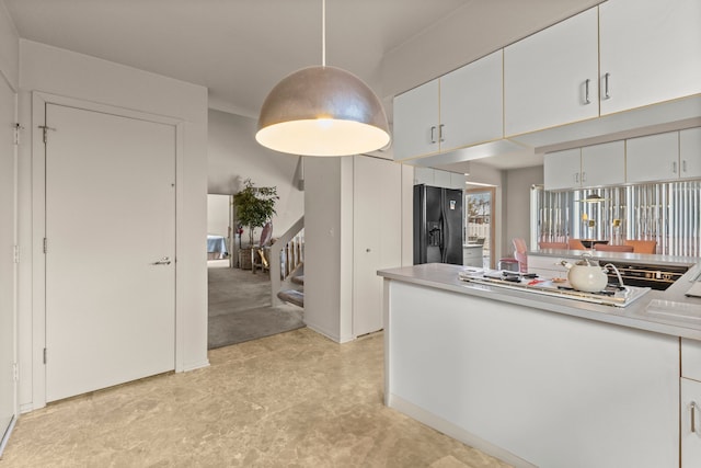 kitchen with pendant lighting, white cabinetry, black refrigerator with ice dispenser, and white gas cooktop