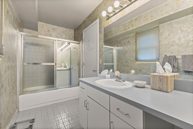 bathroom featuring tile patterned flooring, vanity, and bath / shower combo with glass door