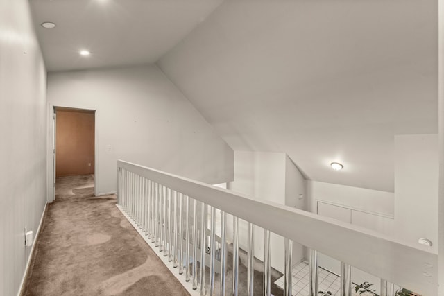 hallway featuring lofted ceiling and carpet flooring