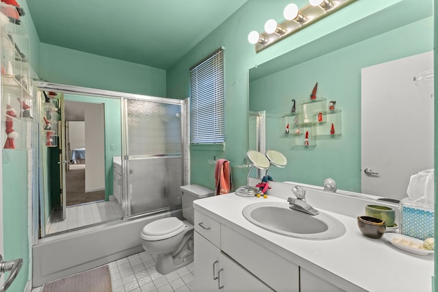 full bathroom featuring vanity, tile patterned flooring, shower / bath combination with glass door, and toilet