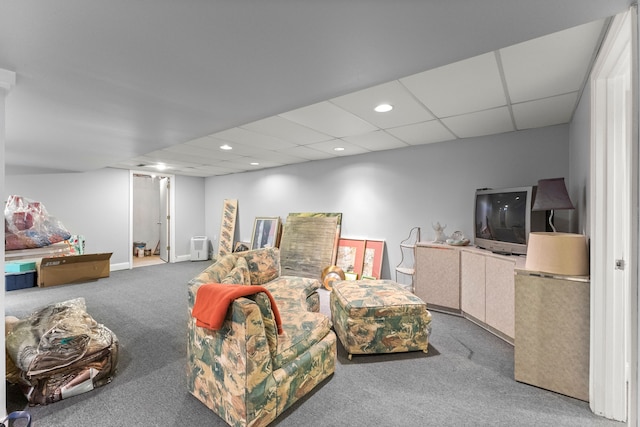 living room featuring carpet flooring and a drop ceiling