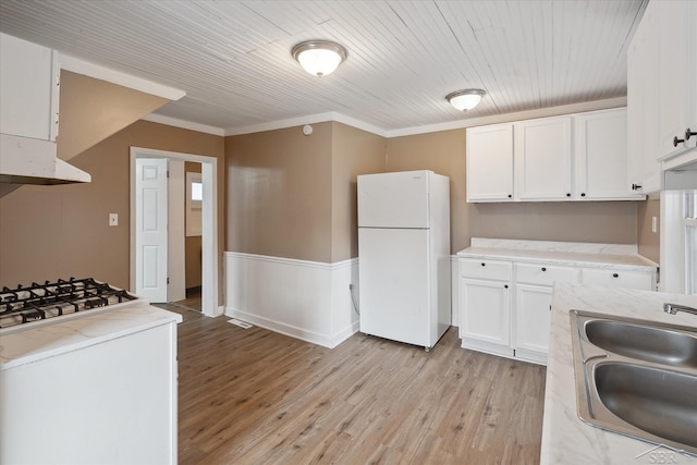 kitchen featuring white cabinetry, sink, white fridge, wood ceiling, and light wood-type flooring