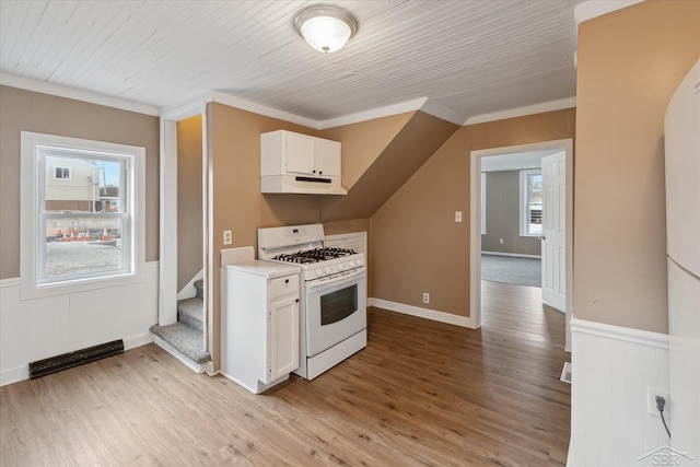 kitchen featuring ornamental molding, white range with gas cooktop, light wood-type flooring, and white cabinets