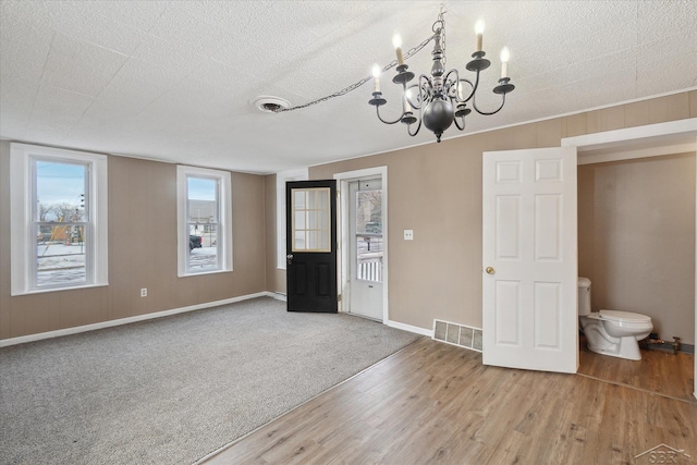 interior space featuring a notable chandelier, wood-type flooring, and a textured ceiling