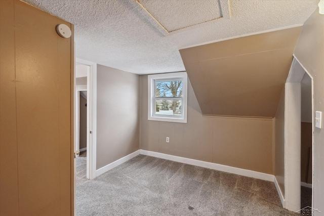 additional living space with lofted ceiling, carpet, and a textured ceiling