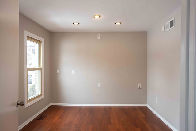 unfurnished room with plenty of natural light and dark hardwood / wood-style flooring