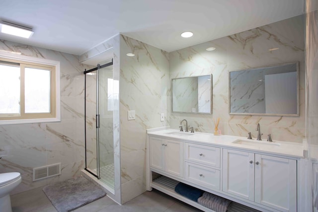 bathroom featuring vanity, a shower with door, and tile walls