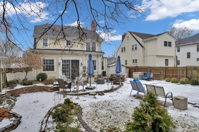 view of snow covered back of property