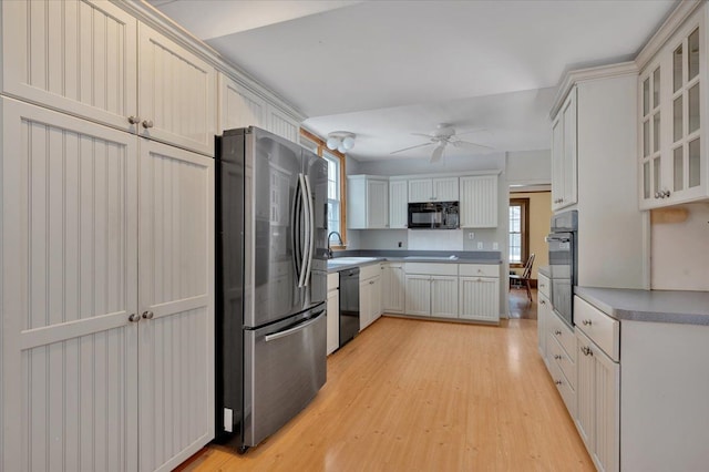 kitchen featuring sink, black appliances, light hardwood / wood-style flooring, ceiling fan, and white cabinets