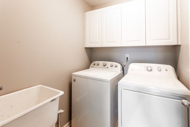 laundry area featuring cabinets, independent washer and dryer, and sink