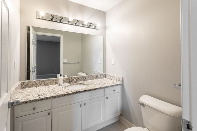 bathroom featuring vanity, tile patterned flooring, and toilet