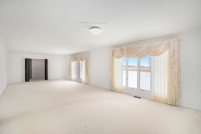 empty room with light colored carpet and a water view