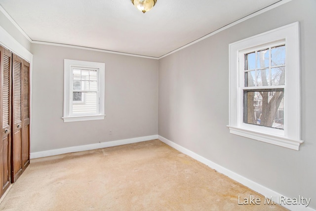 unfurnished bedroom with light colored carpet, ornamental molding, and a closet