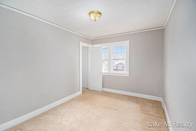 carpeted empty room featuring ornamental molding and a textured ceiling