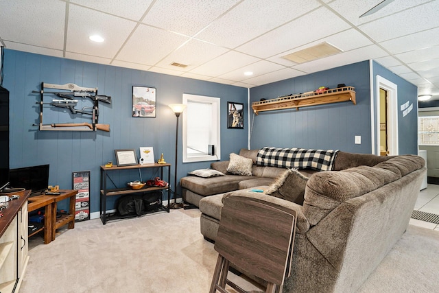 living room featuring light carpet and a drop ceiling