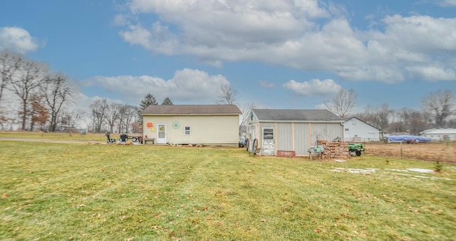 rear view of property featuring an outdoor structure and a lawn