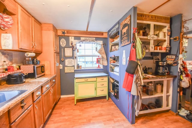 kitchen featuring sink, backsplash, and light hardwood / wood-style flooring