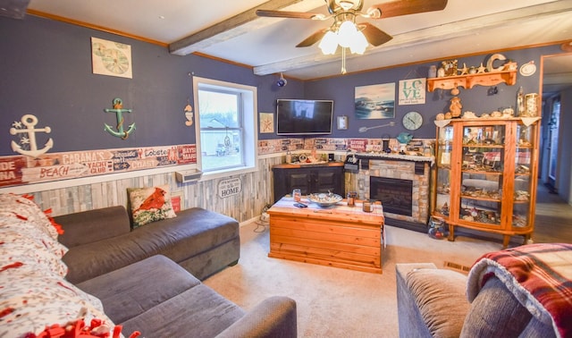 living room featuring a fireplace, wood walls, beamed ceiling, ceiling fan, and light carpet