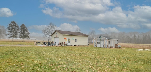 rear view of house featuring a garage, an outbuilding, and a lawn