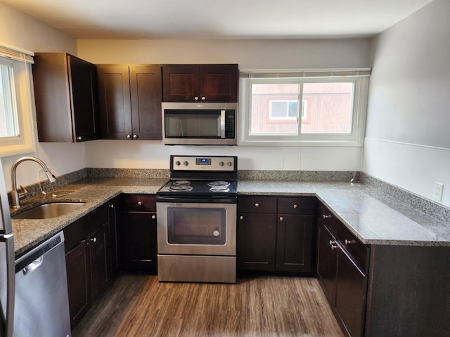 kitchen with hardwood / wood-style flooring, dark brown cabinetry, appliances with stainless steel finishes, and sink