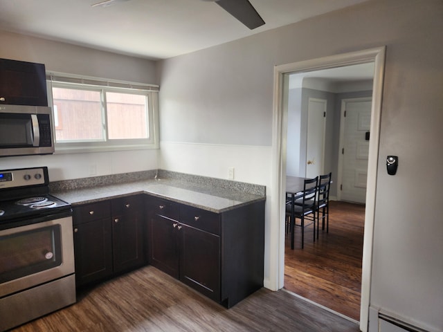 kitchen with a baseboard radiator, stainless steel appliances, and hardwood / wood-style floors