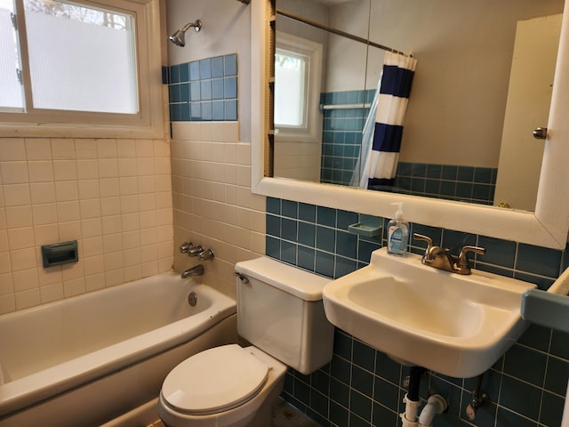 full bathroom with shower / bathtub combination with curtain, sink, tile walls, backsplash, and toilet