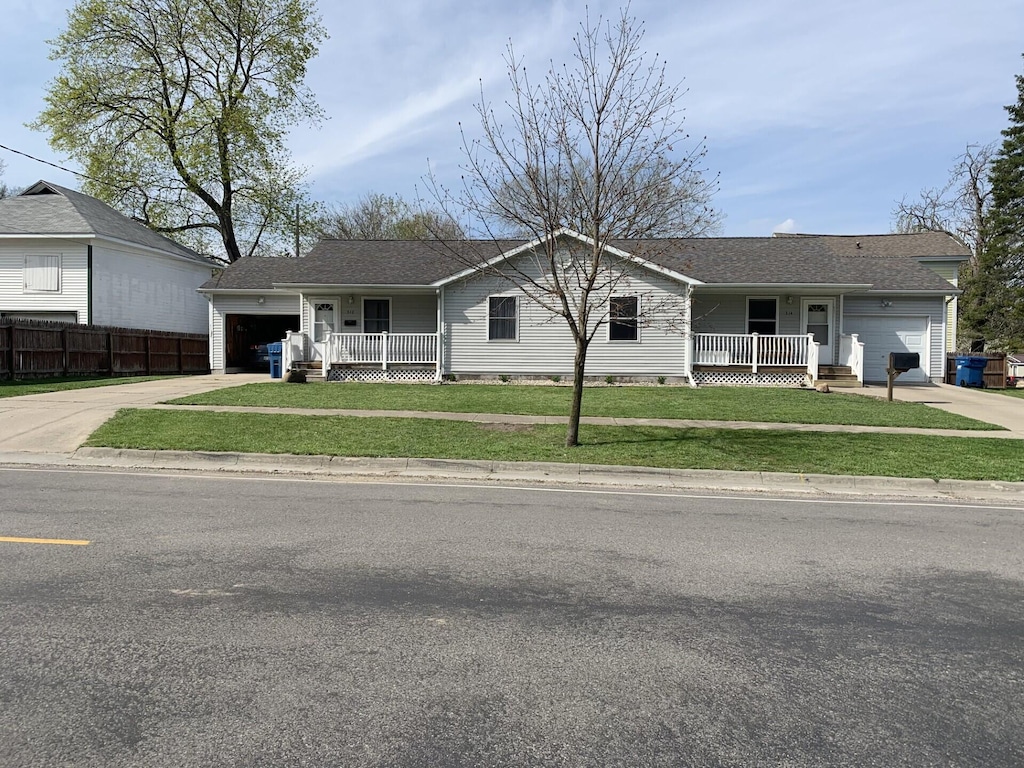 ranch-style house with a garage, a front yard, and a porch