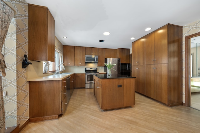 kitchen featuring a center island, brown cabinets, stainless steel appliances, and light wood finished floors