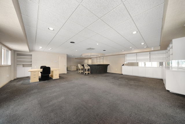 unfurnished living room with recessed lighting, dark carpet, and a paneled ceiling