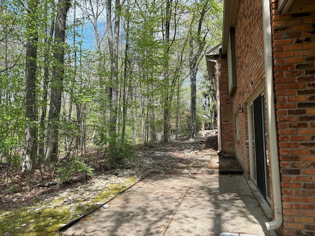 view of side of property with brick siding and a patio