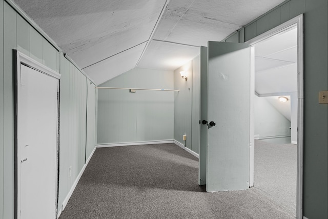 hall with vaulted ceiling and carpet flooring