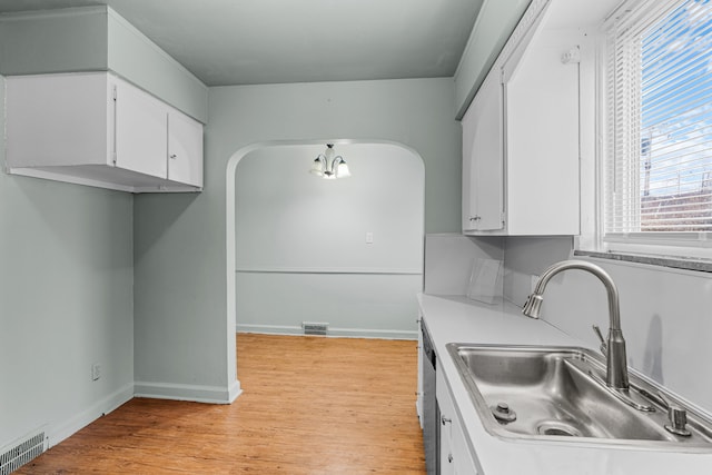 kitchen with light wood-type flooring, sink, and white cabinets