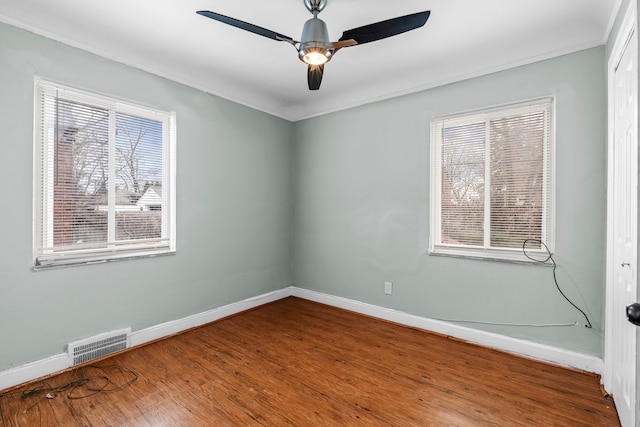 empty room with wood-type flooring, ceiling fan, and crown molding