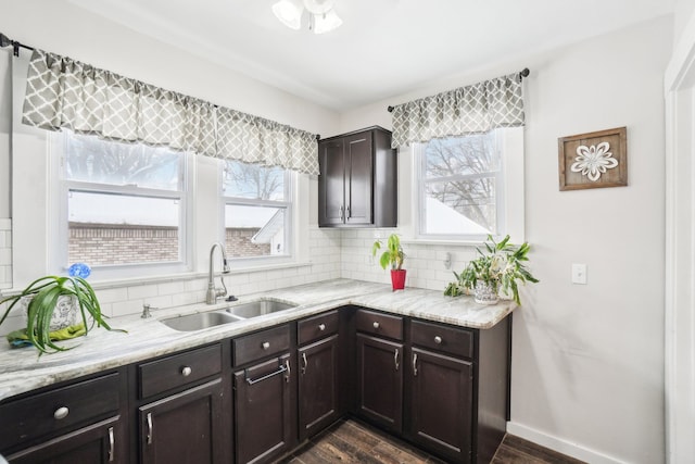 kitchen with a wealth of natural light, a sink, dark brown cabinetry, and decorative backsplash