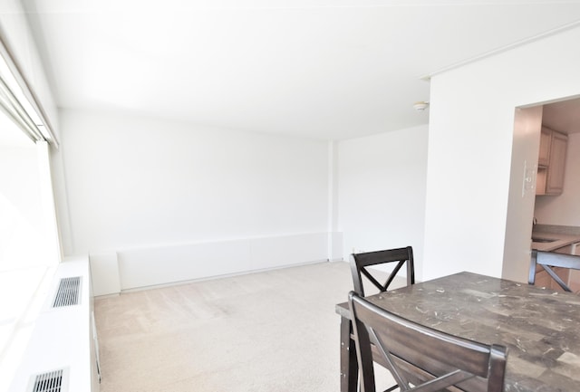 dining space featuring light carpet and sink