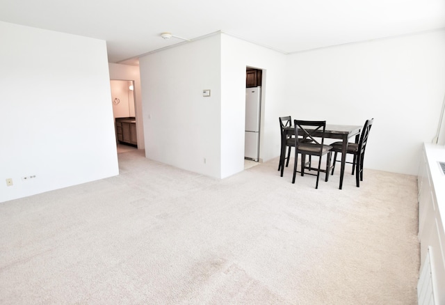 dining space featuring light carpet