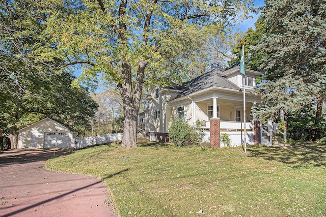 view of side of home with an outbuilding, a garage, a lawn, and a porch