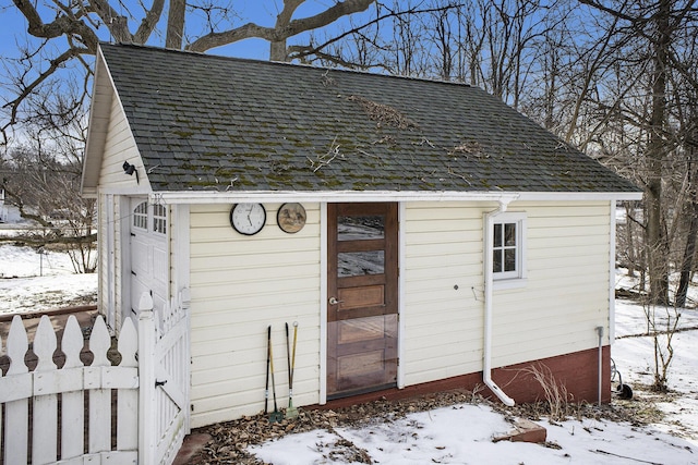 snow covered structure featuring a garage