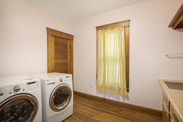 clothes washing area with cabinets, washer and dryer, and dark hardwood / wood-style flooring