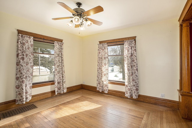 unfurnished room featuring light hardwood / wood-style flooring, decorative columns, and ceiling fan