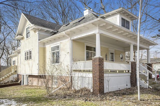 view of side of home featuring covered porch