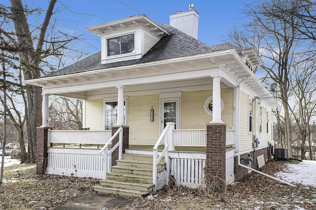 view of front of home with cooling unit and a porch