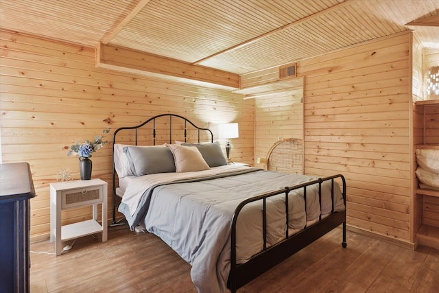 bedroom with hardwood / wood-style flooring, wood ceiling, and wooden walls