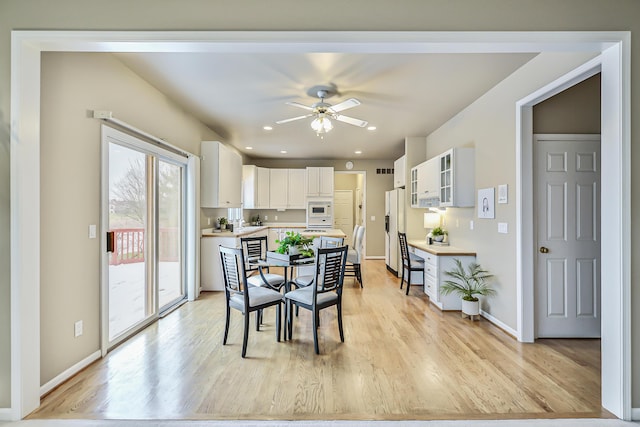 dining area with ceiling fan and light wood-type flooring