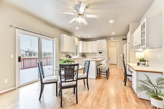 dining area featuring ceiling fan and light wood-type flooring