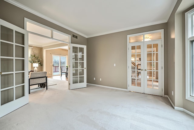 spare room with french doors, ornamental molding, and light carpet