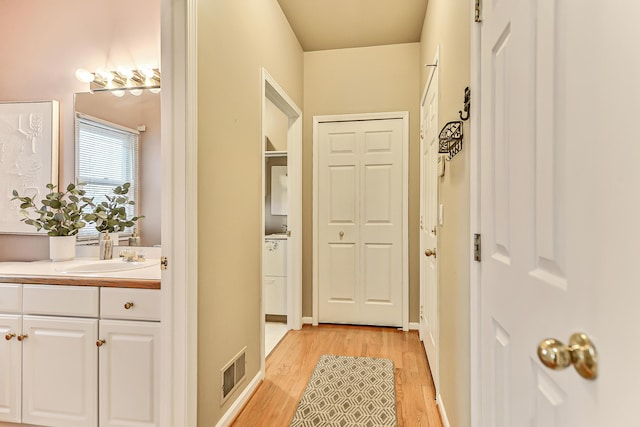 hall featuring sink and light hardwood / wood-style floors