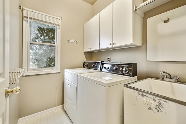 laundry room featuring cabinets, sink, and washer and clothes dryer