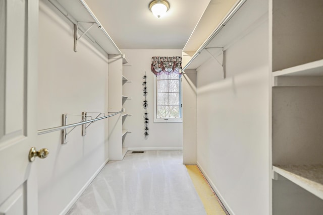 walk in closet featuring light colored carpet